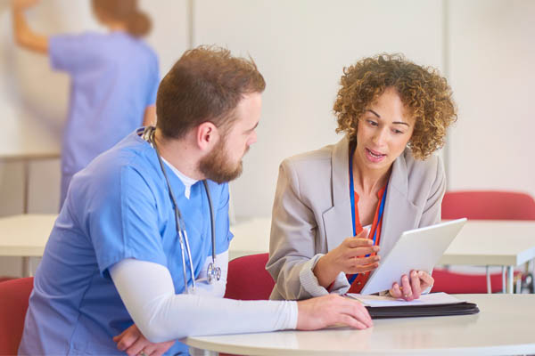 Health Information Tech talking to a healthcare professional