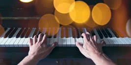 Hands playing piano at night