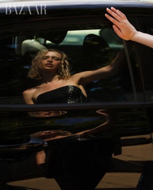 Model seen through a car window wearing a black strapless top.
