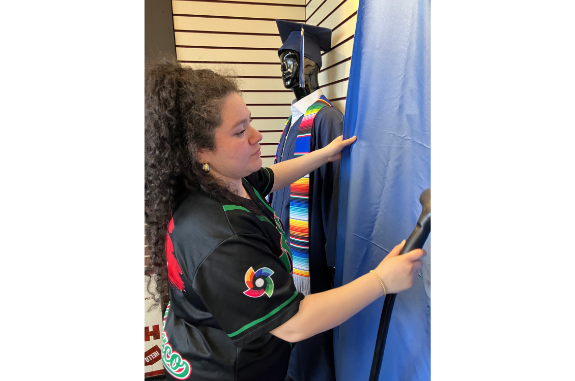 A student using a steamer to smooth out the wrinkles in the backdrop for the display window