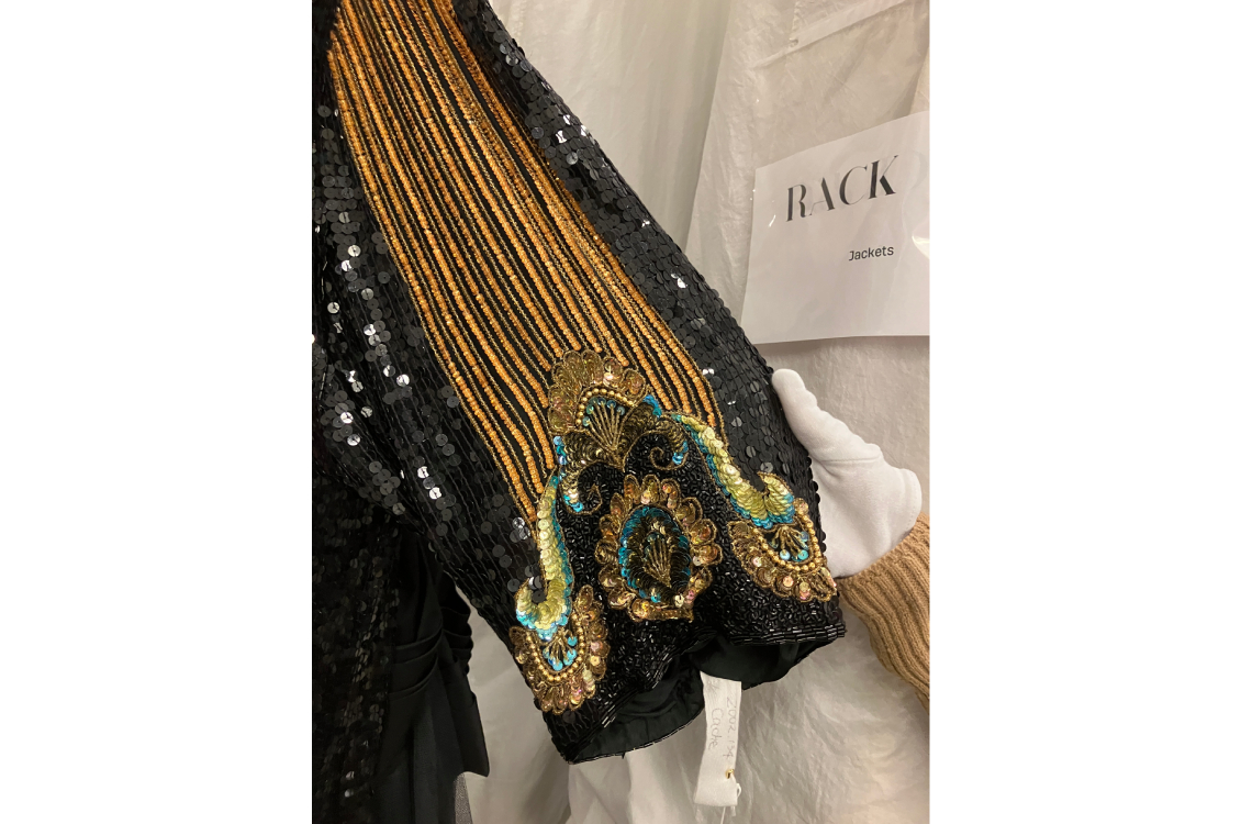 Detail of peacock inspired embellishments on beaded and sequined coat.