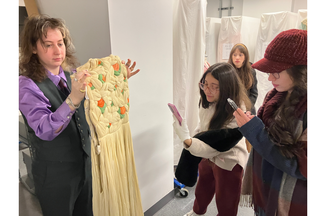 Students examine cream, orange and green gown by French couture designer Madame Grés.