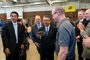 His Excellency Shinsuke J. Sugiyama holds a metal spider made in Harper's manufacturing lab