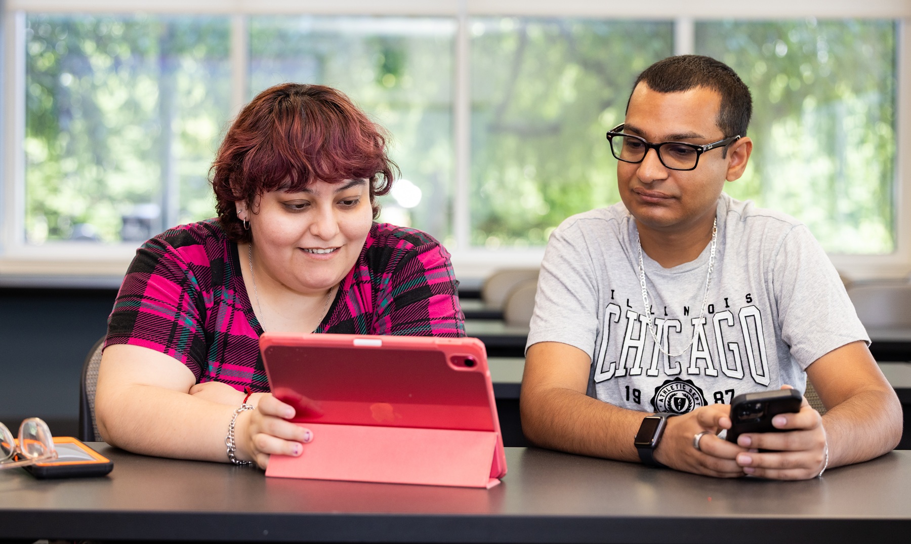 A student and instructor look at a tablet equipped with an AI-powered note-taking app