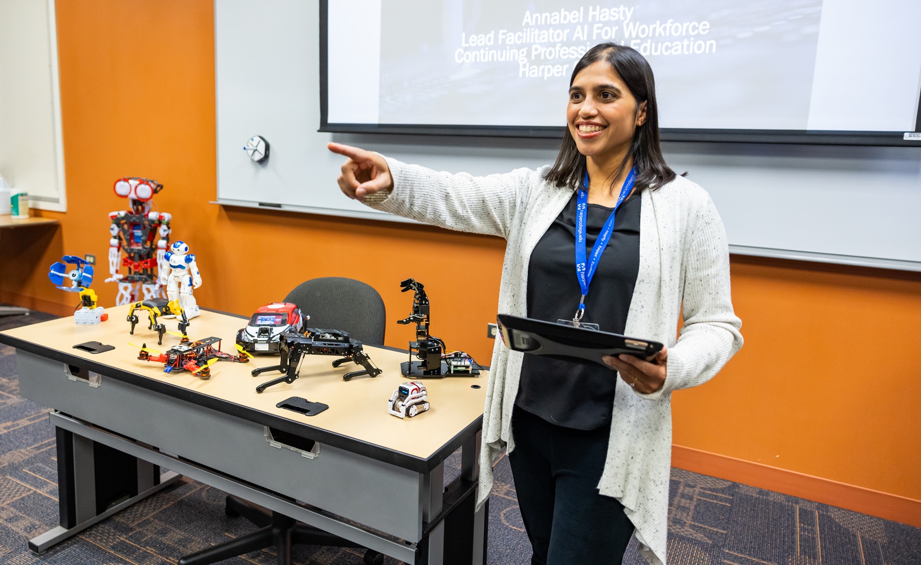 Anabel Hasty AI degree Harper College Instructor Anabel Hasty stands in a computer lab with robotic AI tools
