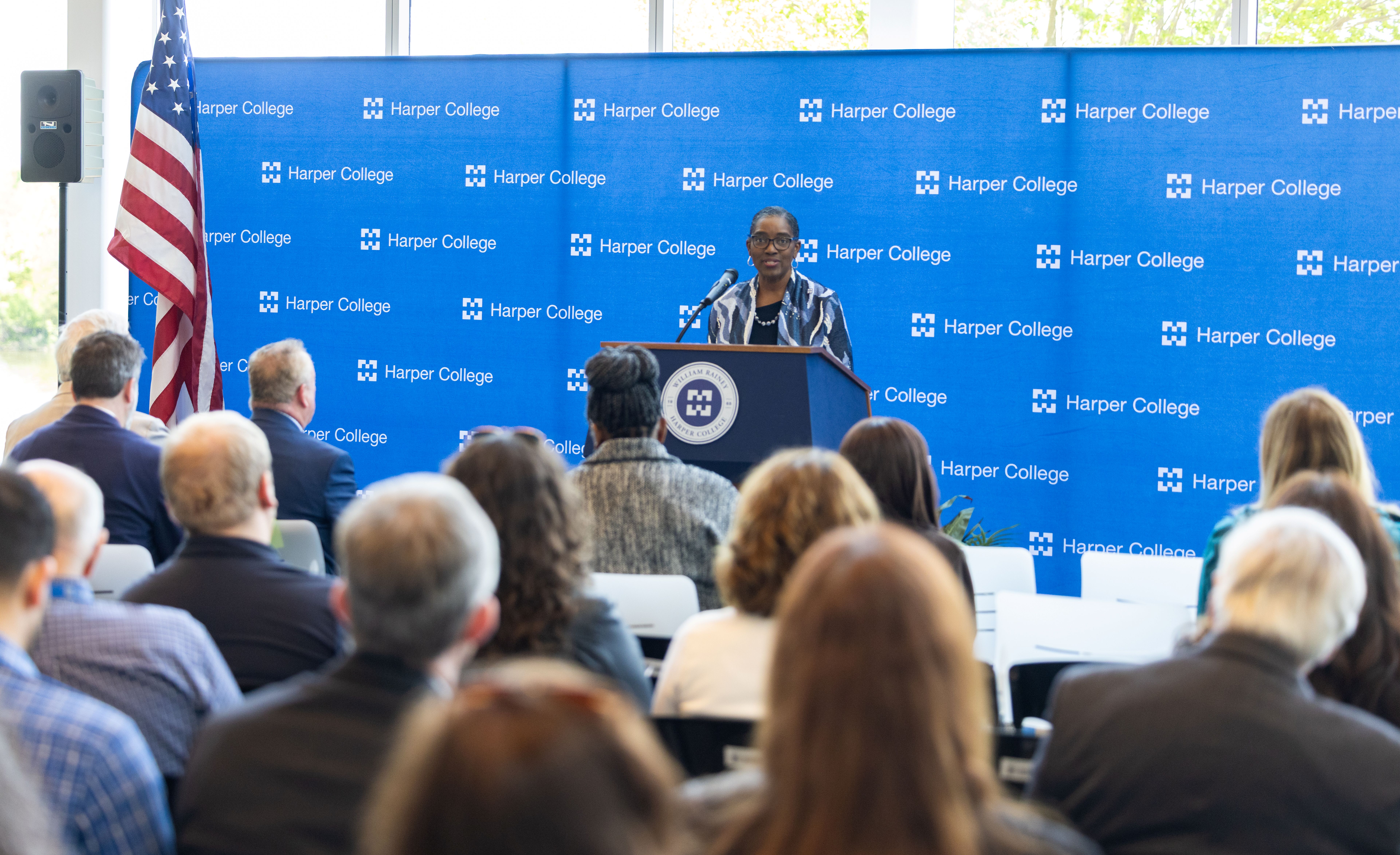 Dr. Avis Proctor speaks at the podium at the beam-signing ceremony