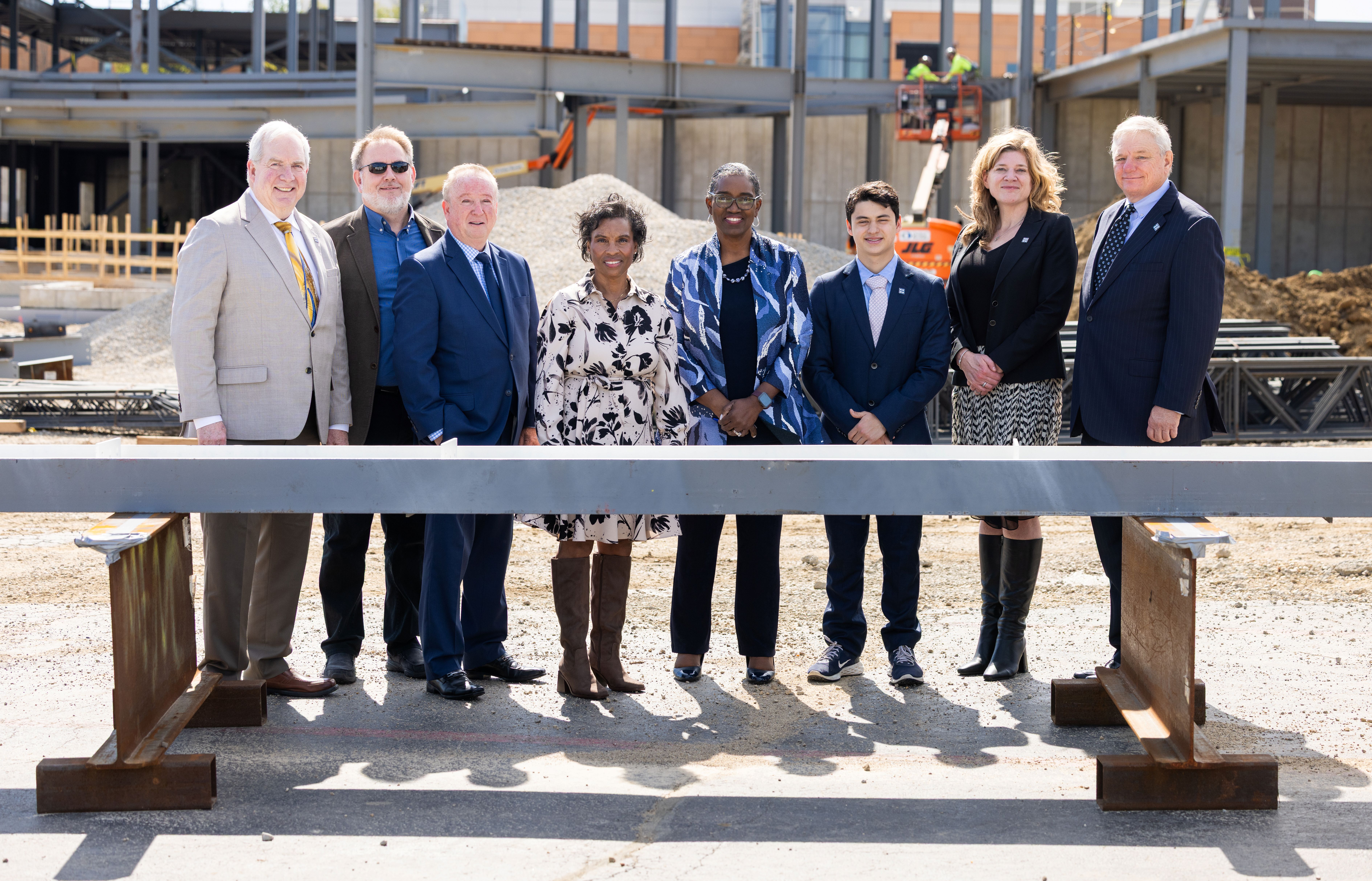 Harper College leaders stand beside the signed beam at the beam-signing ceremony