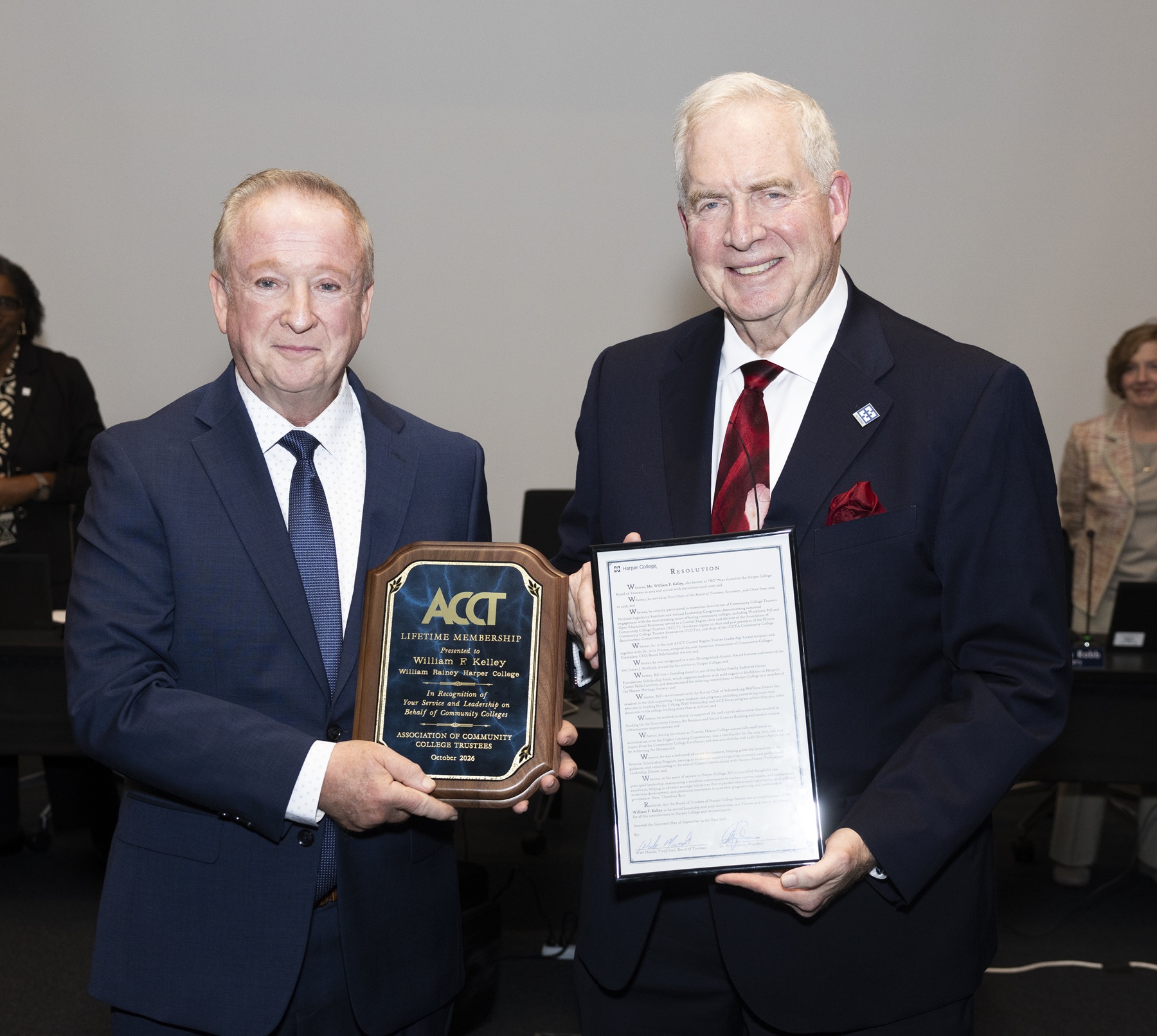 Walt Mundt and Bill Kelley stand with a resolution honoring Bill's 23 years of service to the Harper College Board of Trustees.
