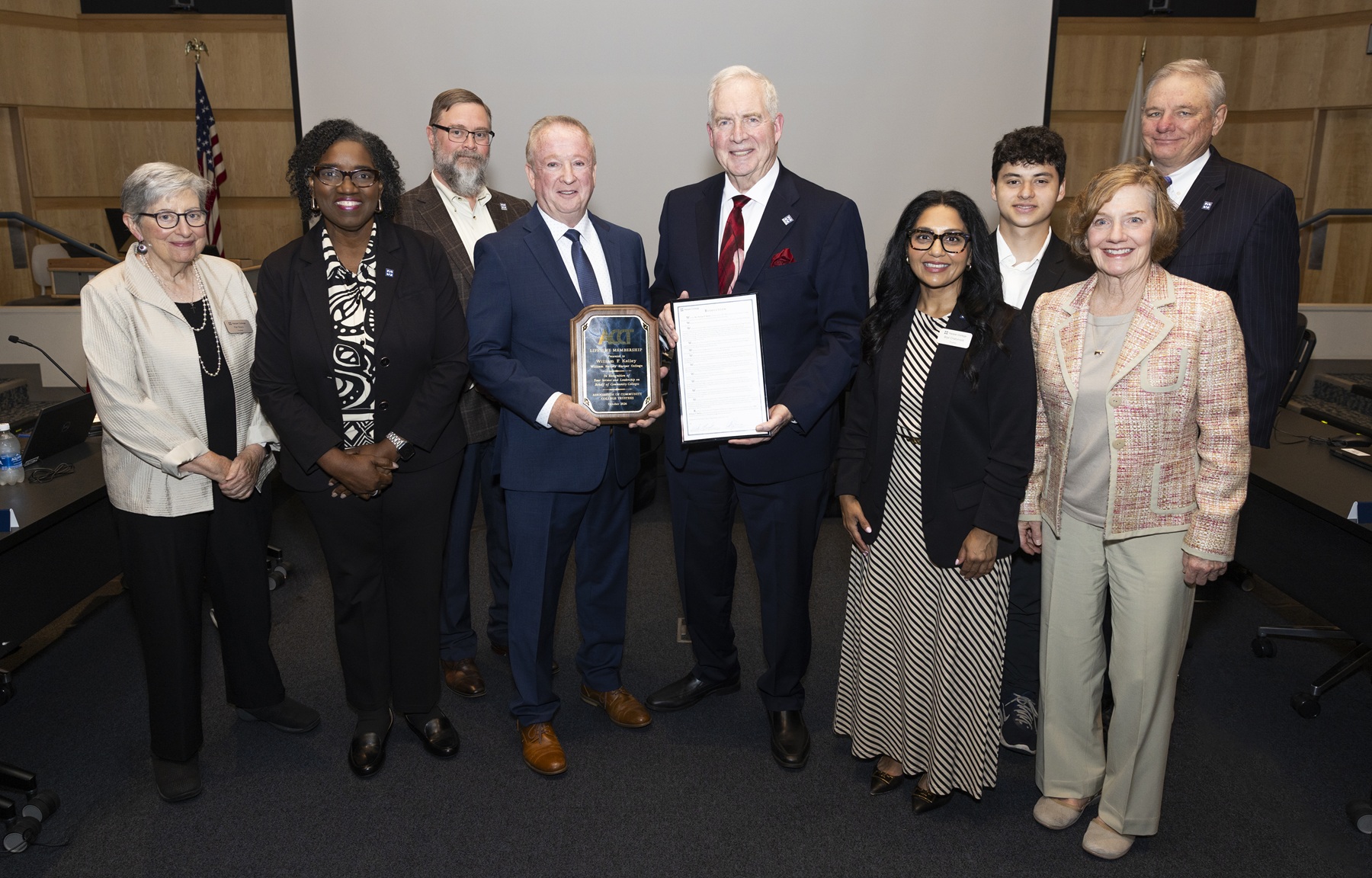 The Harper College Board of Trustees stands with Trustee Emeritus Bill Kelley after honoring him.