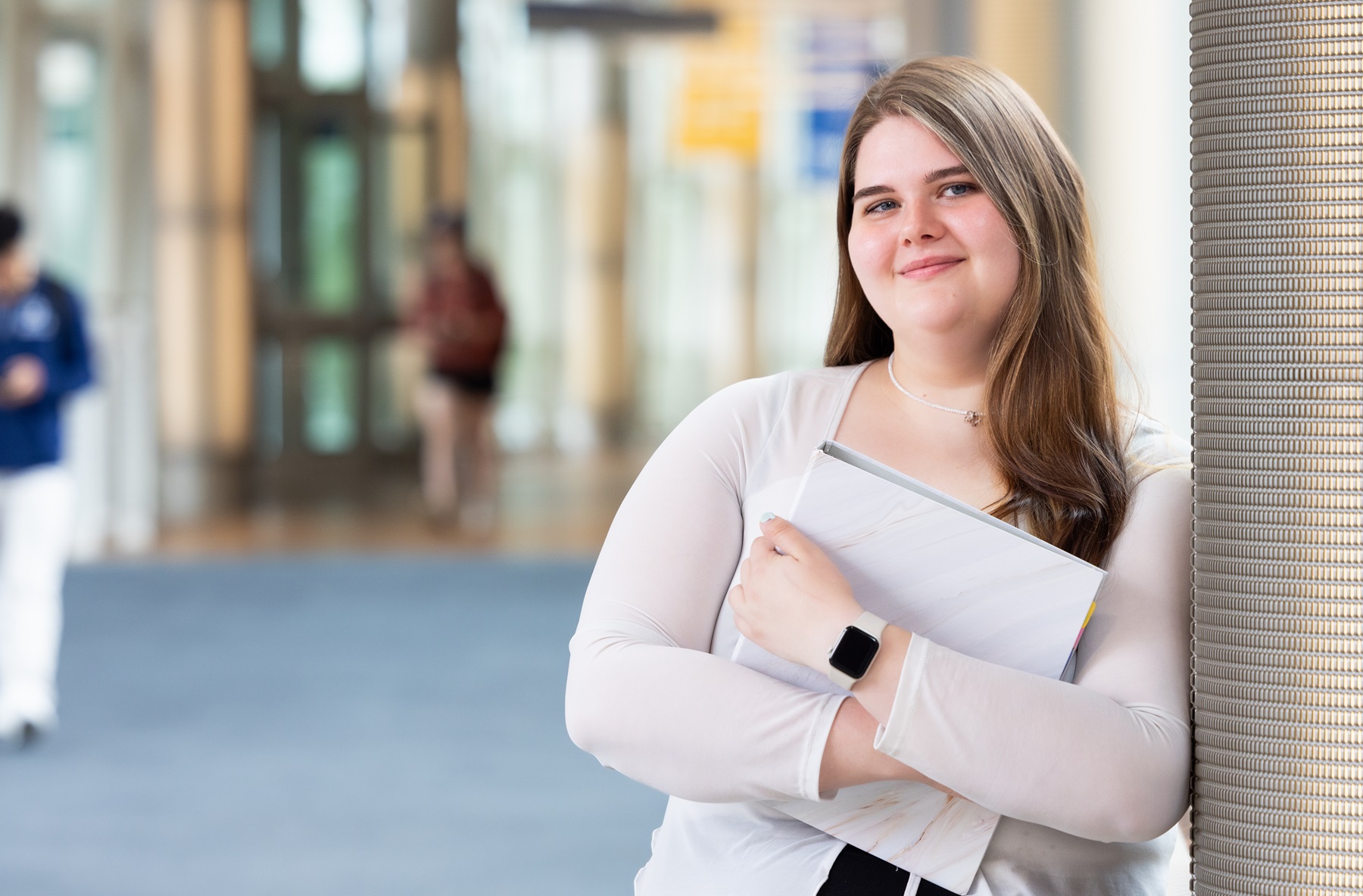 Brittney Raker stands with her computer at Harper College.