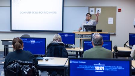 An instructor leads a Community Education computer class for adults.