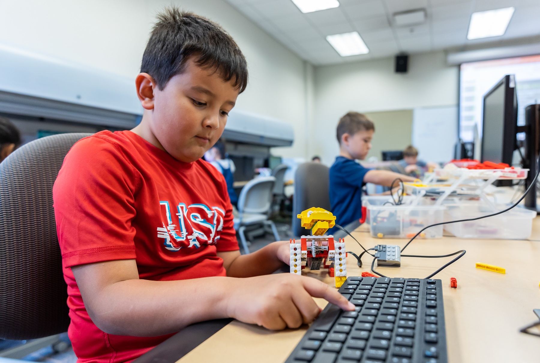 CE InZone Young students work with Lego bricks and computers in an InZone class