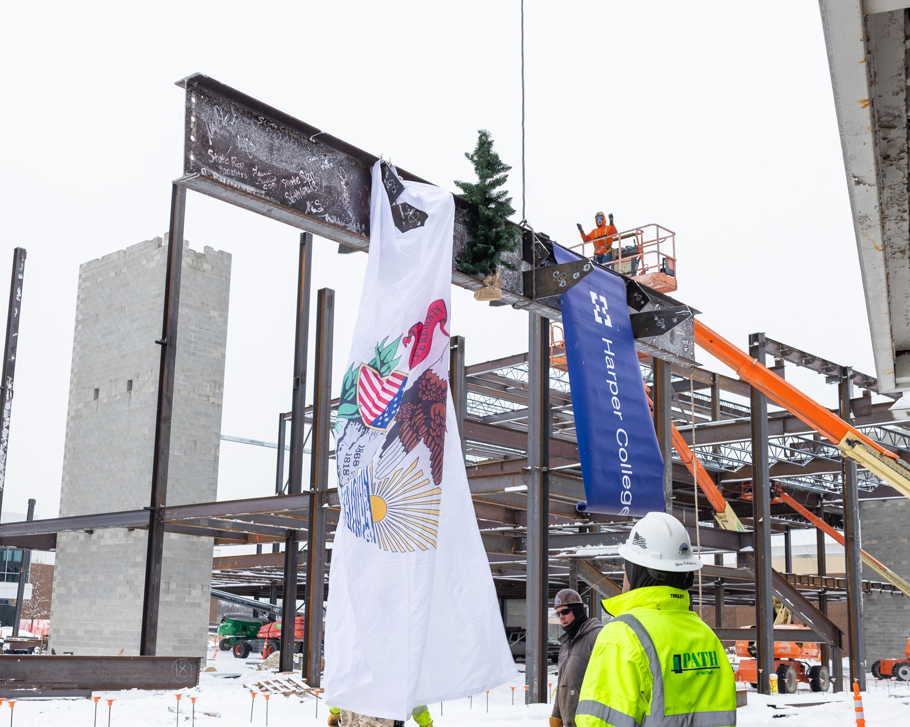Construction crews place a beam with signatures on it from Harper leaders, elected officials and many others.