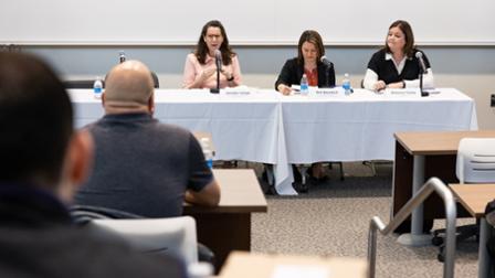 Harper alumni speak at a table in front of an audience of Harper students
