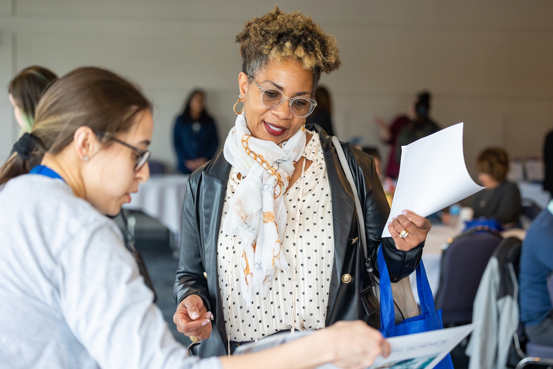 An adult student interacts with Harper College employees at the Career Forward event