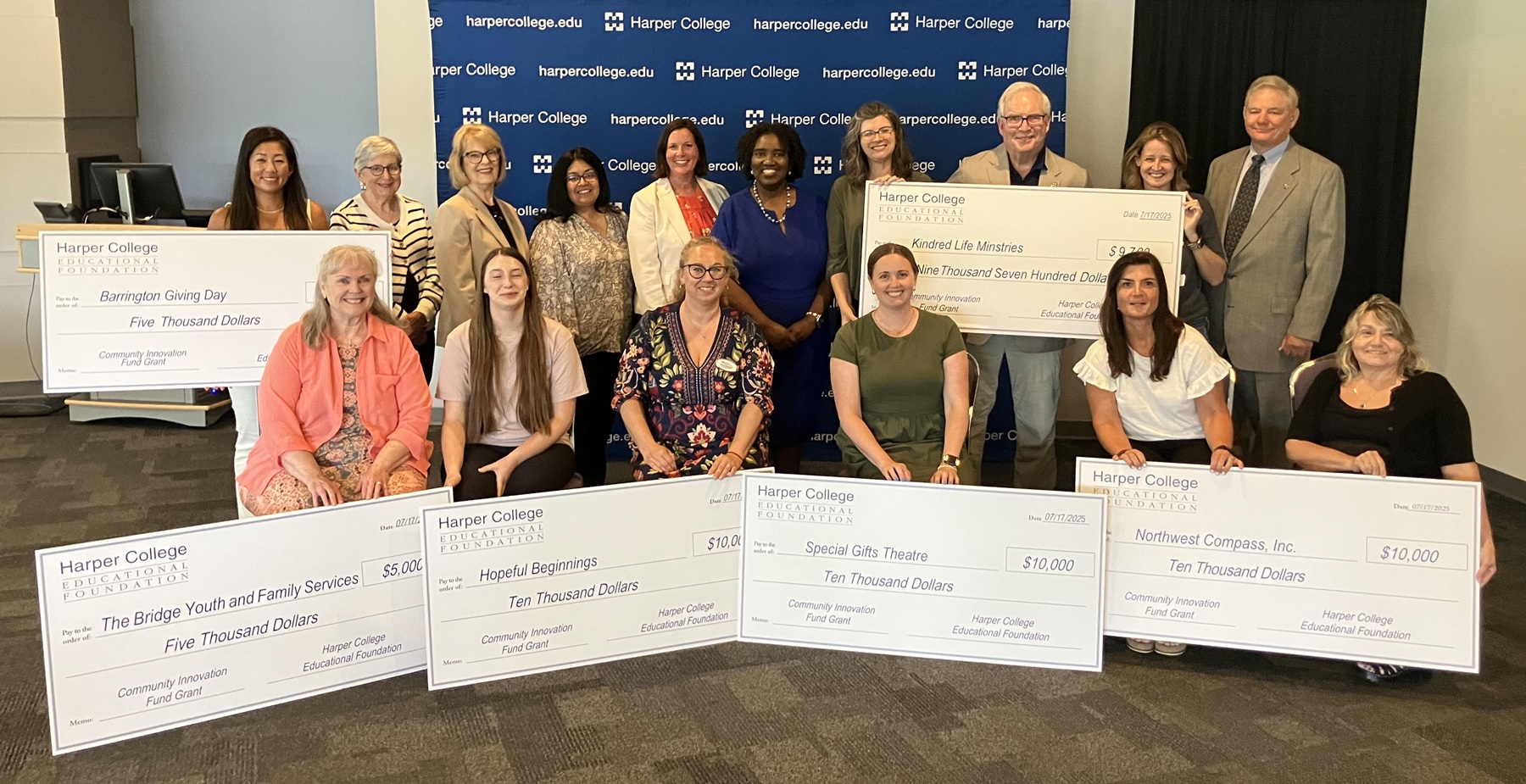 Community Impact Fund Grant recipients stand with Harper College leaders and ceremonial checks