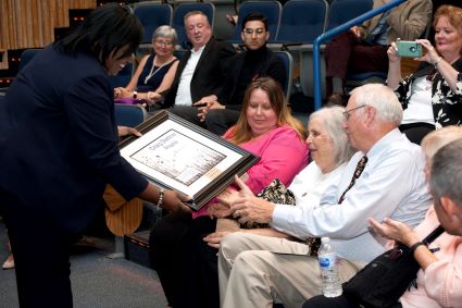 Dr. Avis Proctor presents a plaque to Craig Stettner's family