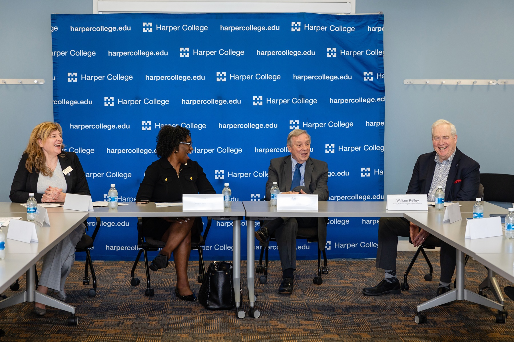 Dr. Ruth Williams, Dr. Avis Proctor, Sen. Dick Durbin and Bill Kelley laugh while sitting during a discussion at Harper College.