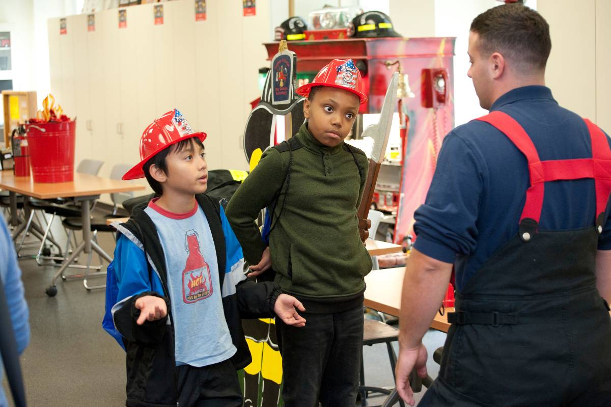 Two boys talk to fire science student