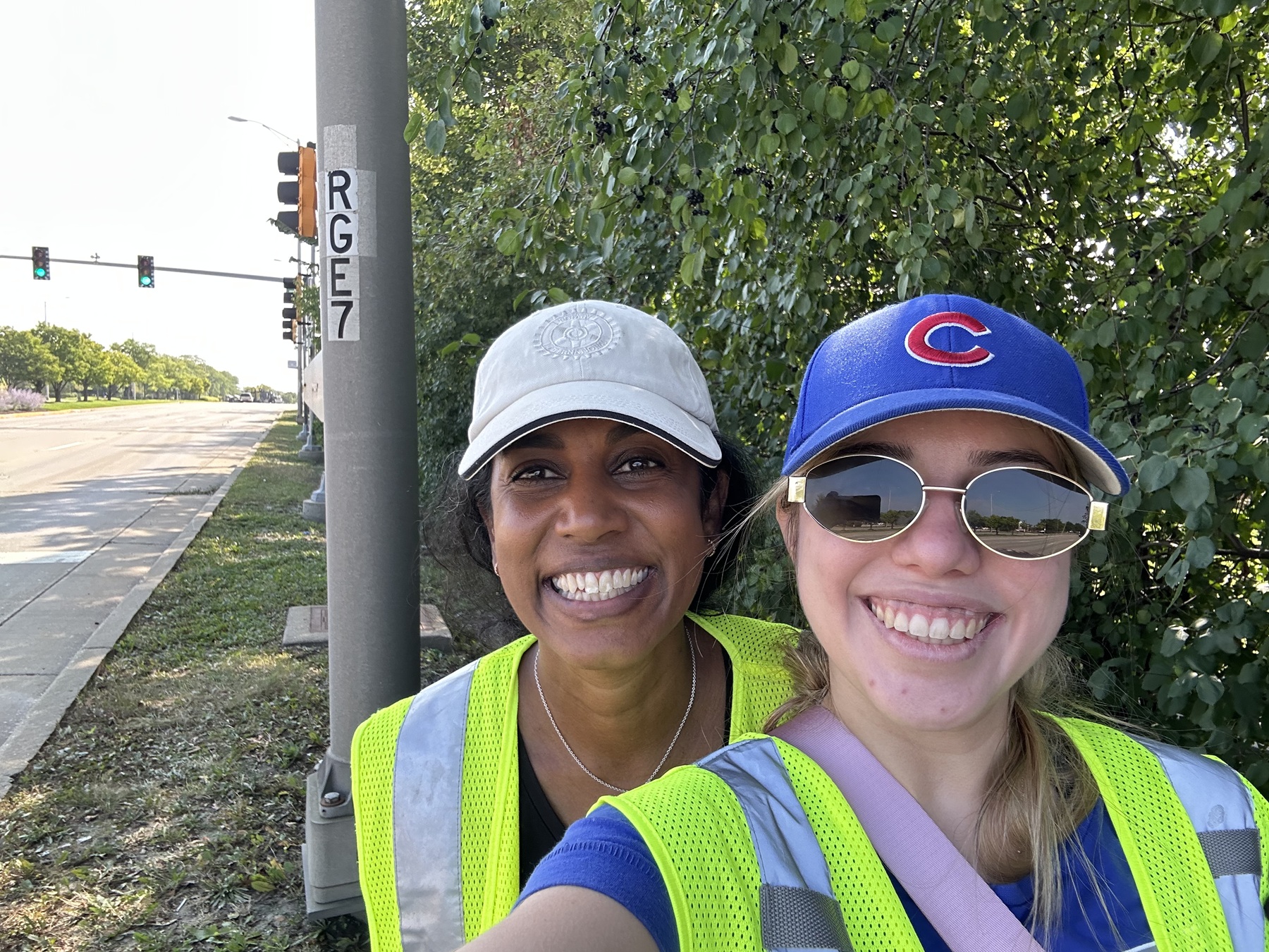 Rotary member Debbie Schmidt and Harper alumna Mariana Alcantara Gonzales wear caps and brightly colored vests while performing community service