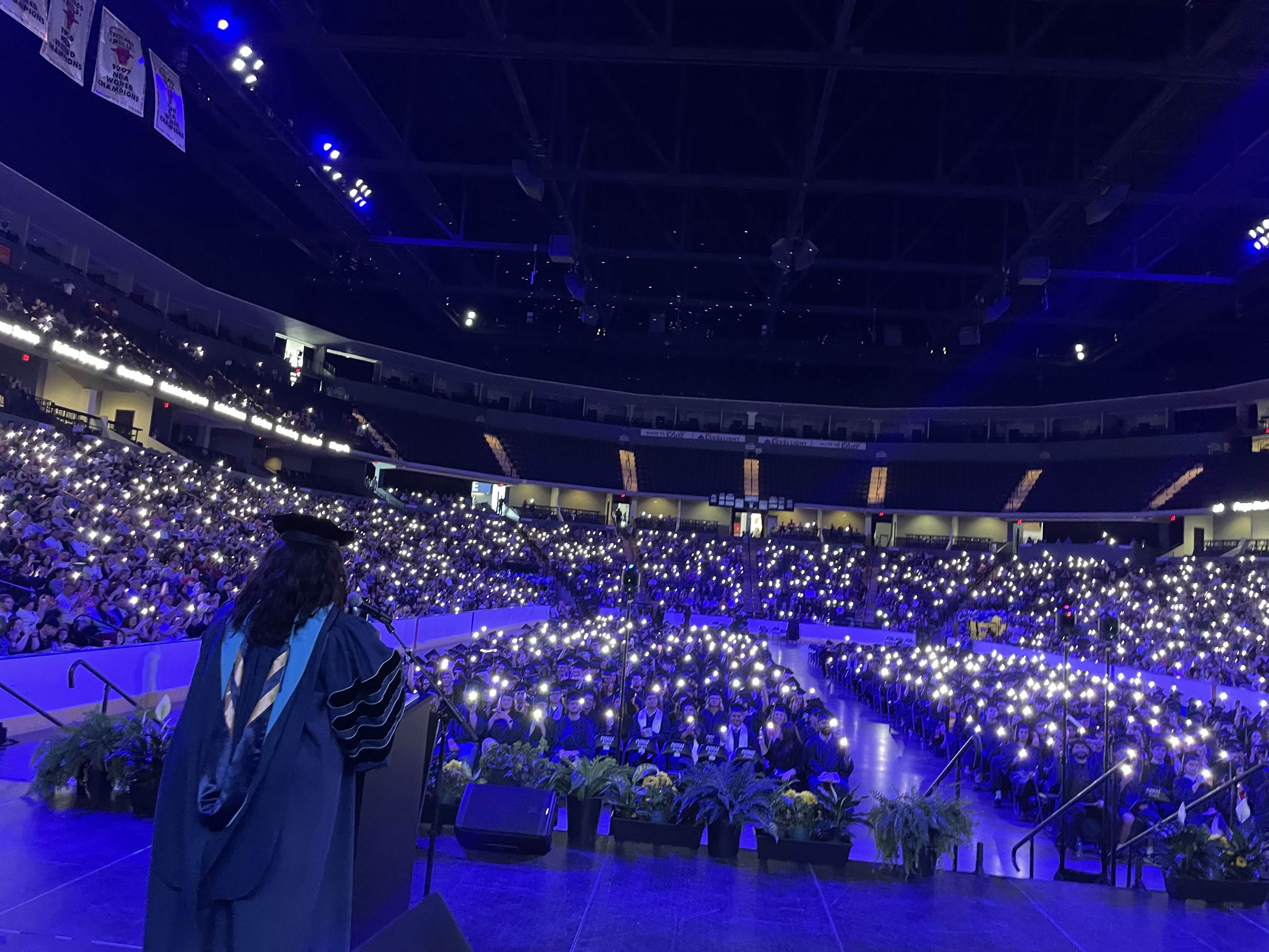 Harper College graduates hold up their cell phone lights