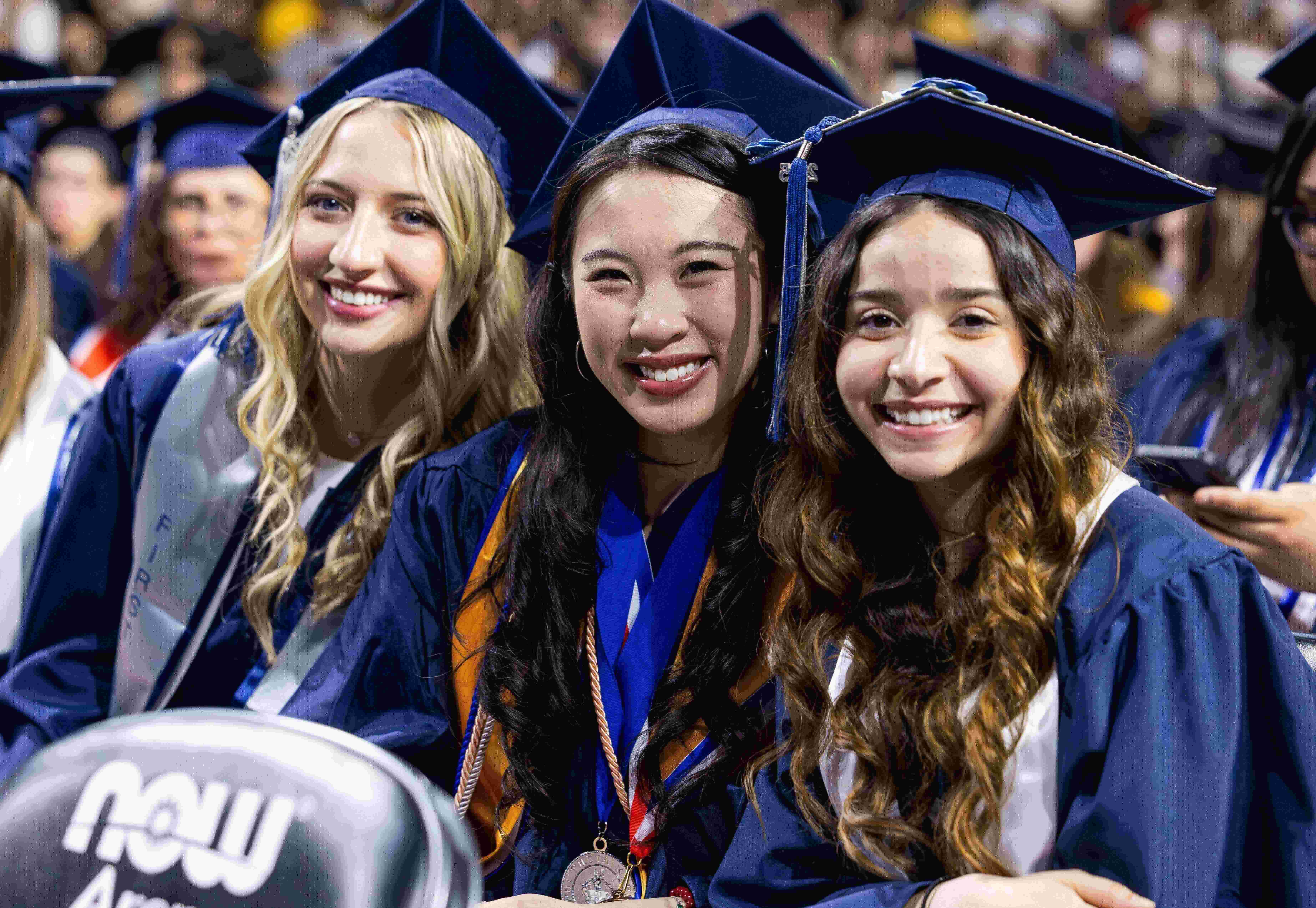 Three graduates smiling