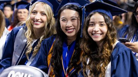Three Harper College graduates smile during Commencement