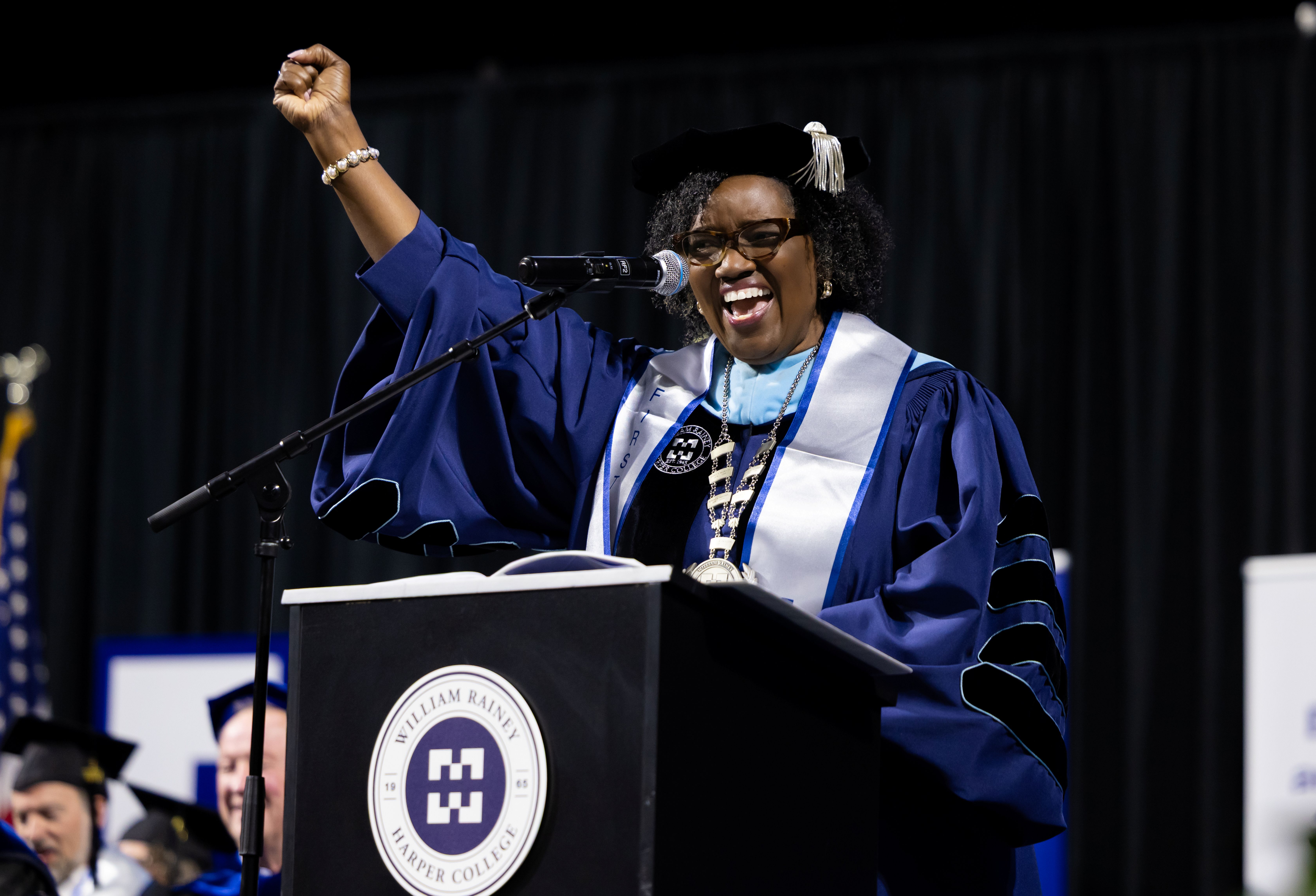 Harper College President Dr. Avis Proctor celebrates on stage at the Commencement ceremony