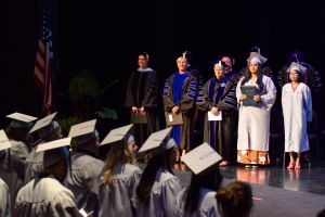 Harper's trustees, administrators and HSE graduation speakers stand on the stage