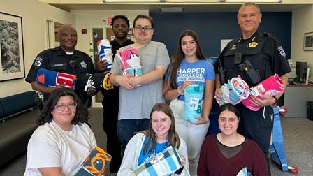 Members of the Harper Police Department and Hawks Care staff hold donated blankets