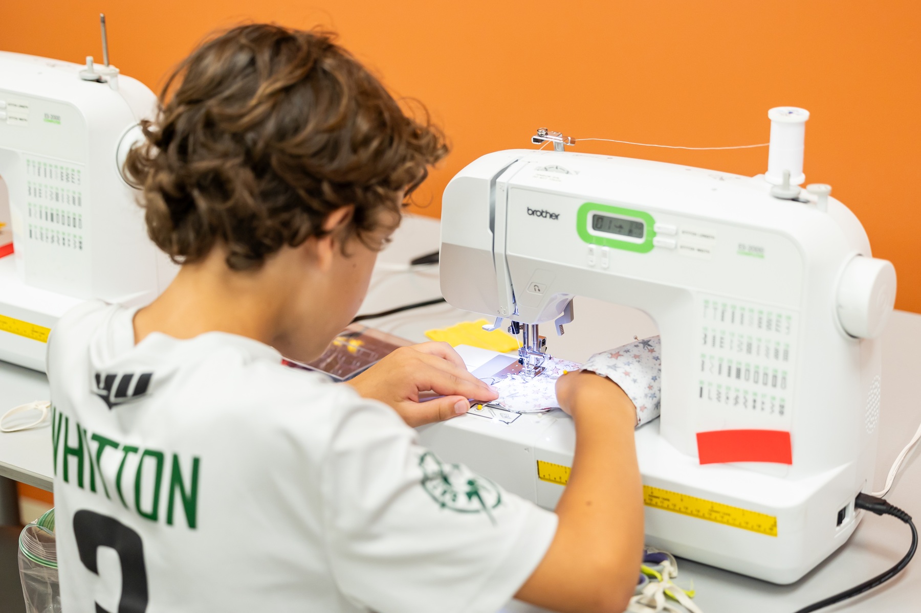 An InZone camper works at a sewing machine