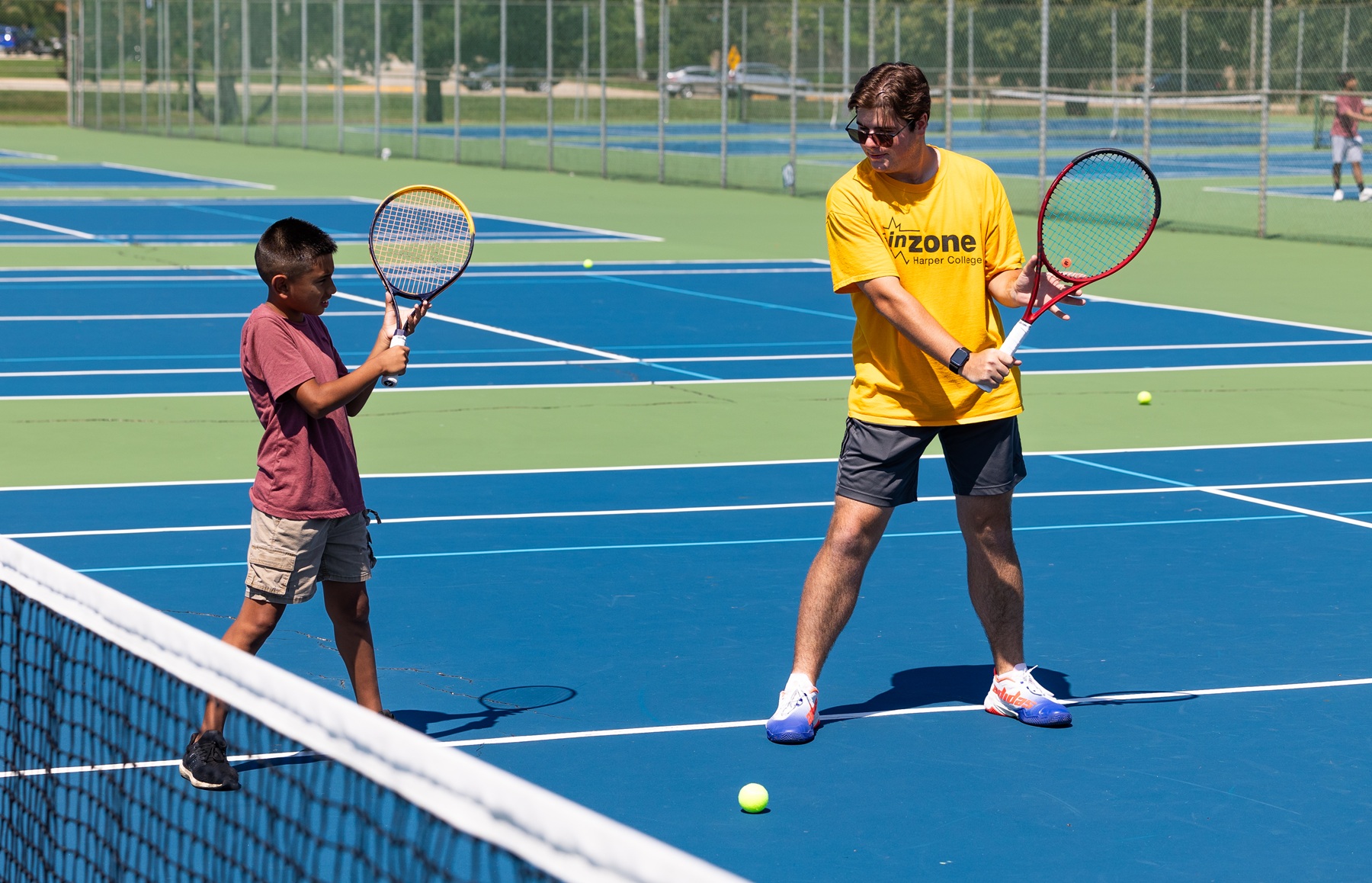 An InZone camper works on his tennis skills with an instructor