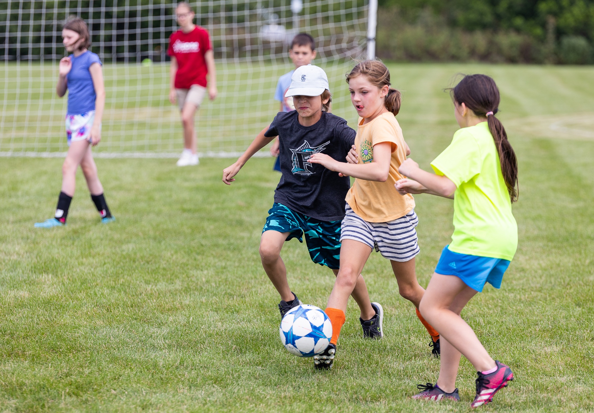 Young students play soccer on a Harper College field during an InZone course