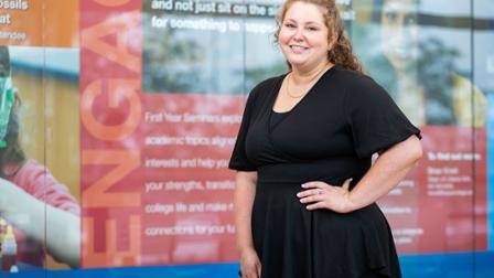 Kelsey Lewis stands in front of display case in the Avante Center.