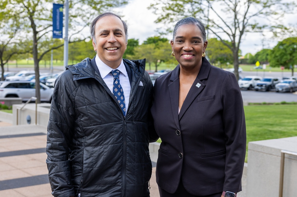 Rep. Raja Krishnamoorthi stands with Dr. Avis Proctor outside Harper College