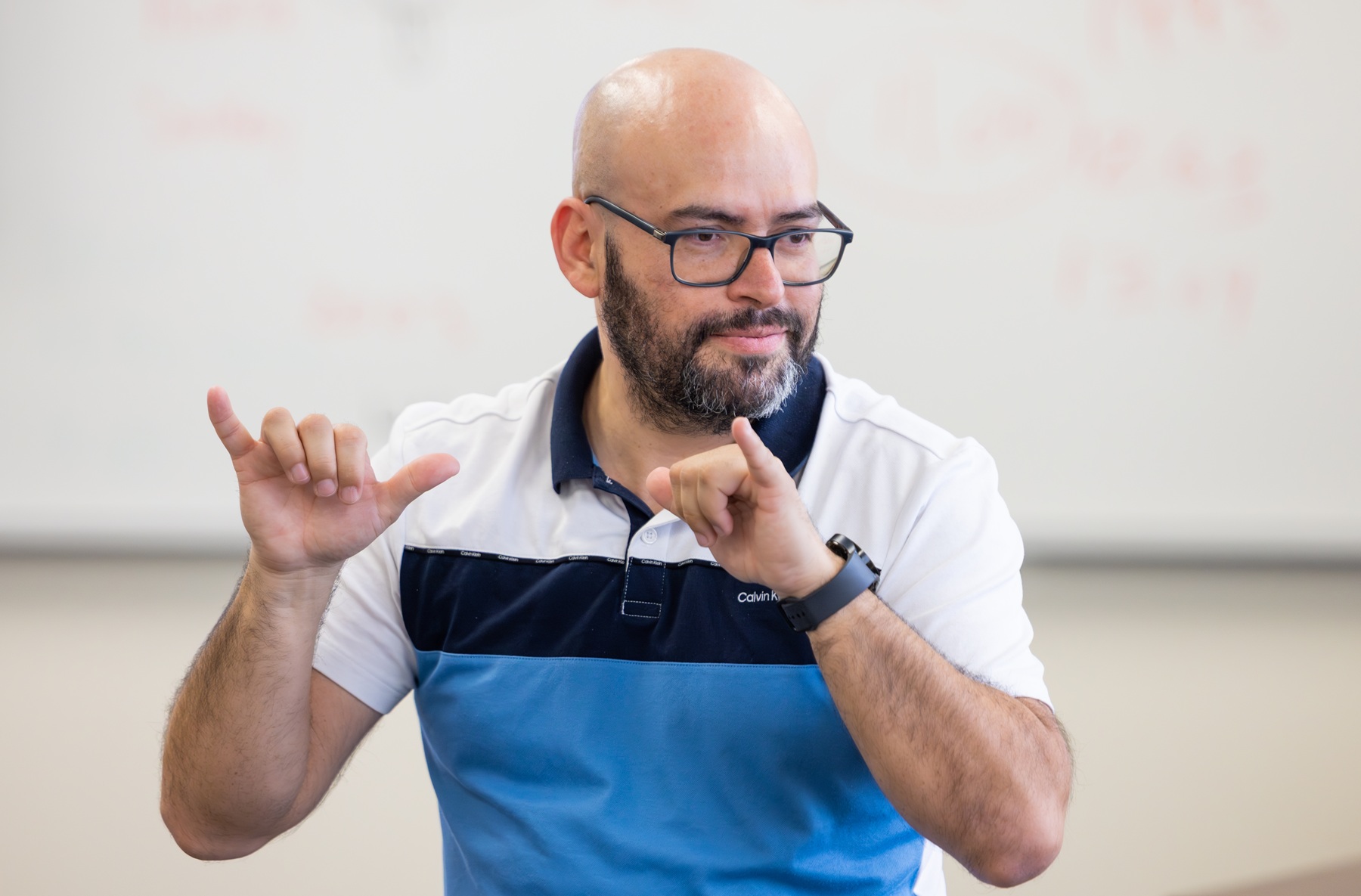 Marcos Aguilar signs in ASL during a class