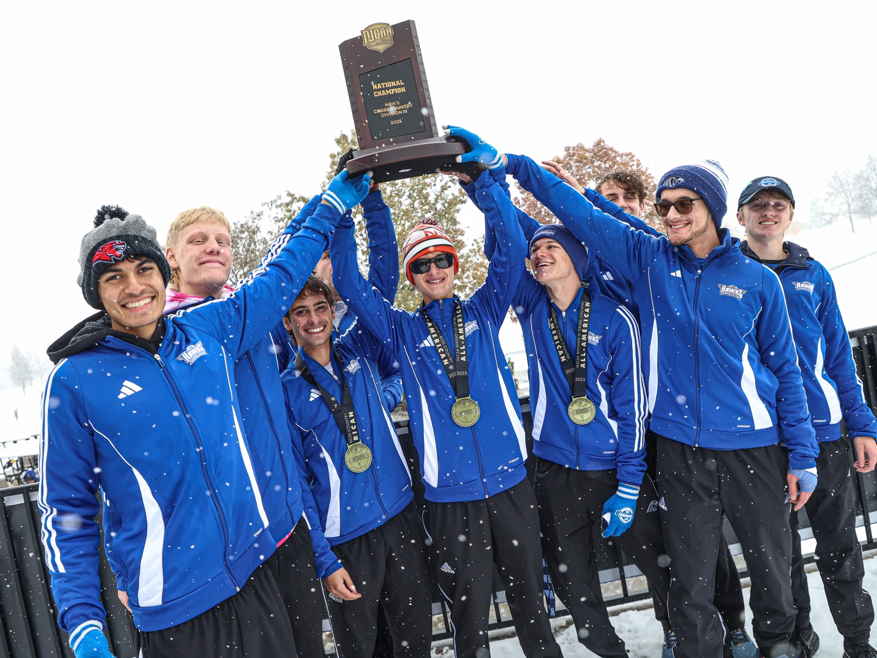 Harper Men's Cross Country teams hoist their national title trophy in the snow