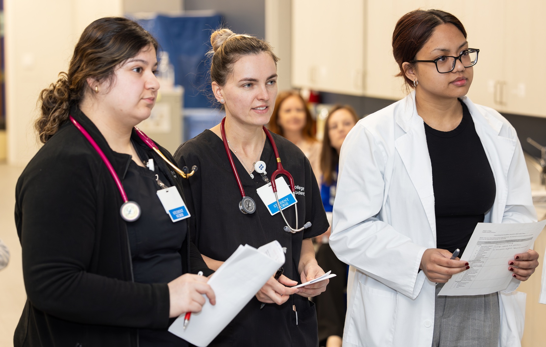 A group of students listens to an instructor