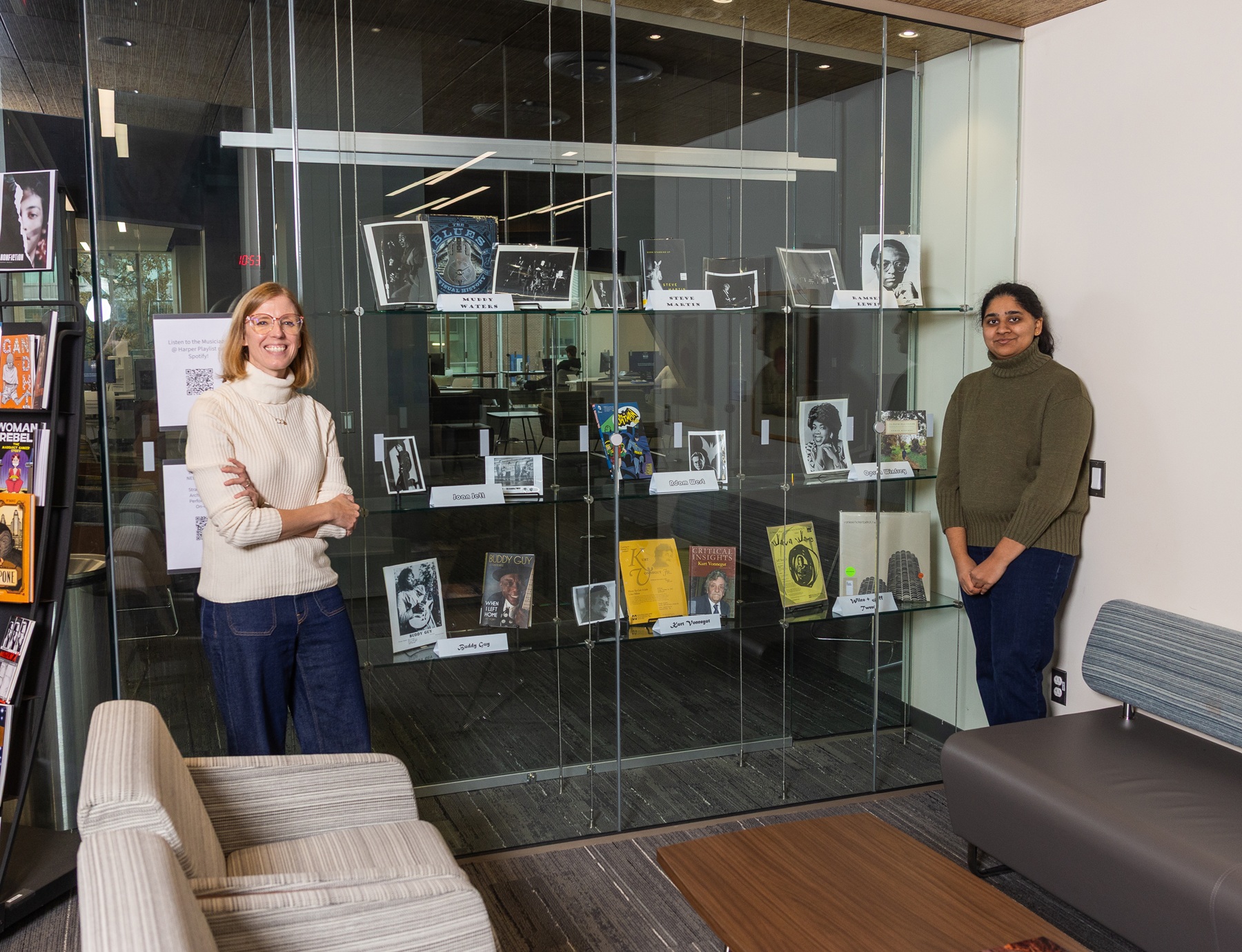 Archivist Brandi Fialek and student aide Madhumitha “Madhu” Manivannan stand next to an exhibit about famous performers who appeared at Harper College.