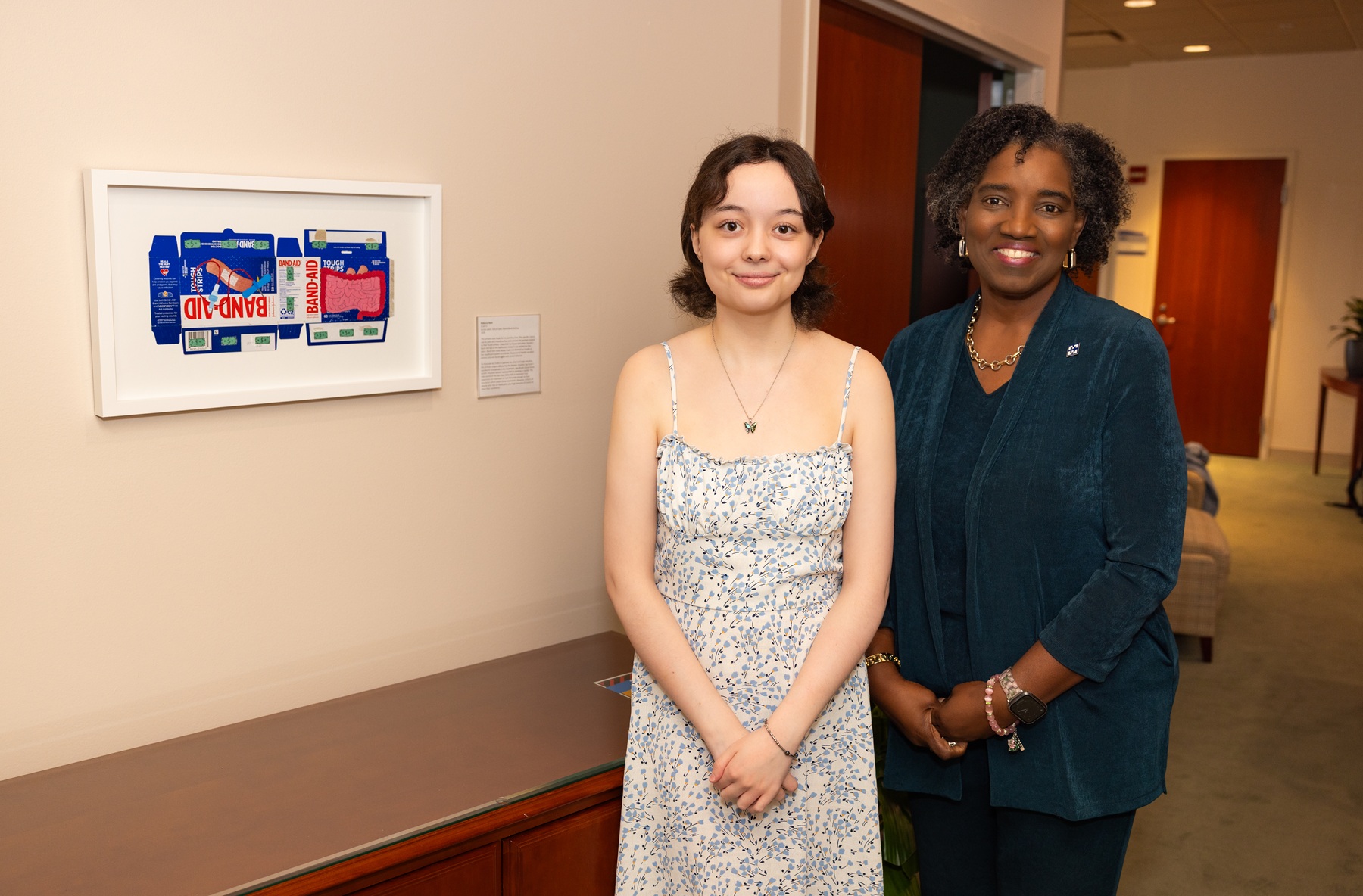 Harper College alumna Becky Reck stands in front of her artwork next to Dr. Avis Proctor