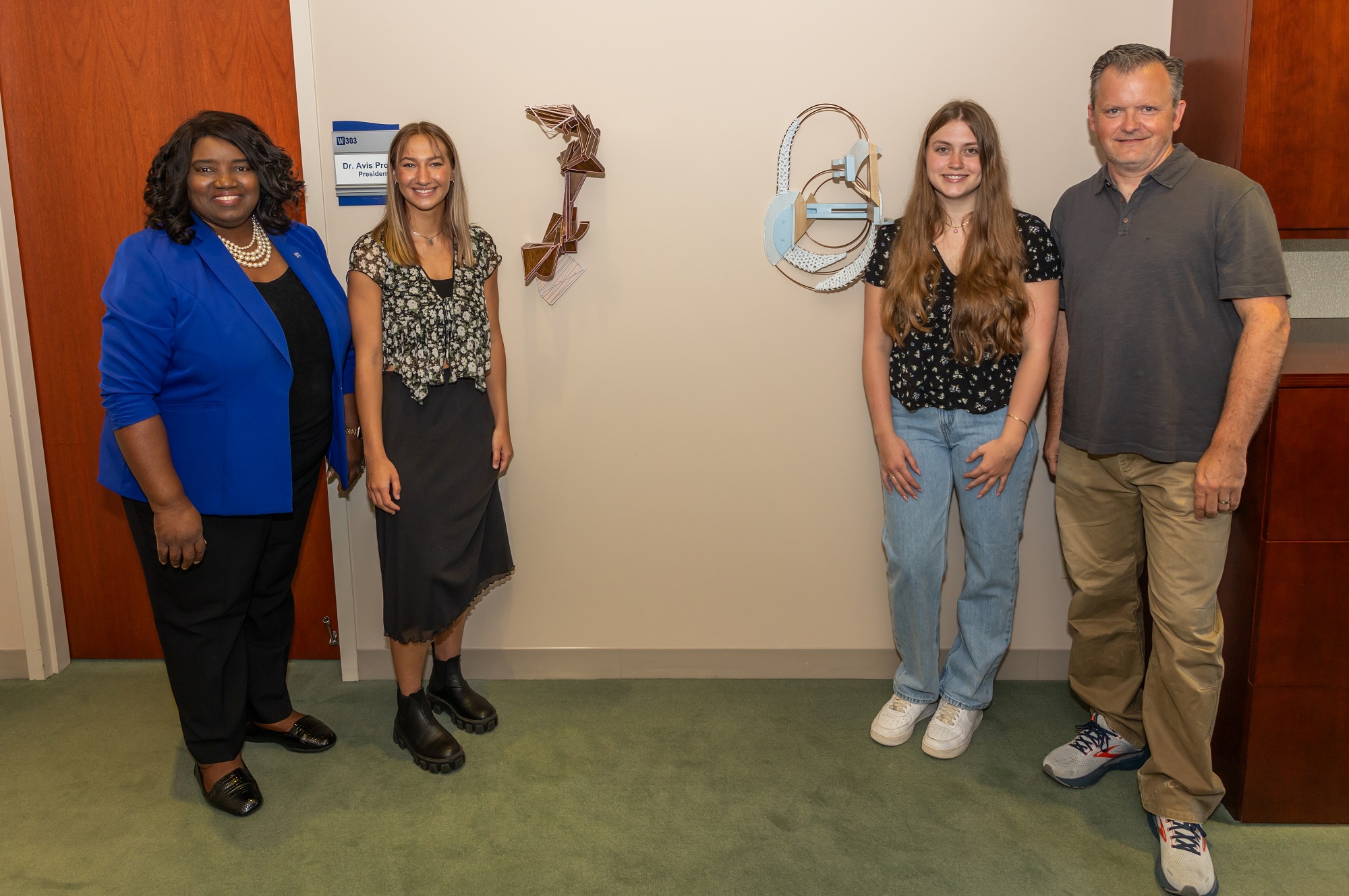 Dr. Avis Proctor, Harper College president, stands with Olivia Maliszewski, Caitlin Baier and Professor Jason Peot, along with Olivia's and Caitlin's statues.