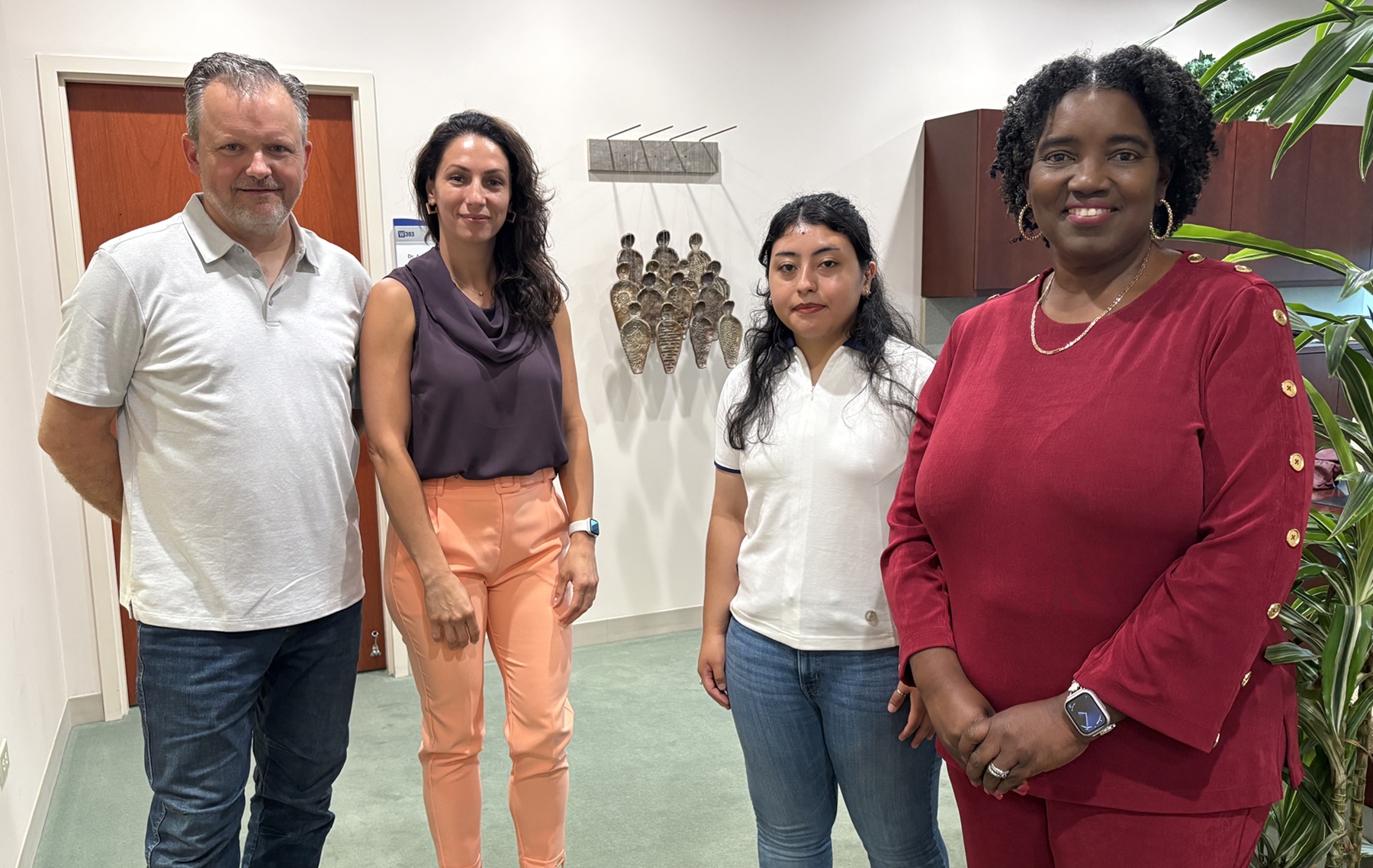 Professor Jason Peot, alum Ana Roussev, student Isabel Guerrero and Dr. Avis Proctor pose in front of Ana's "Ancestral Threads."