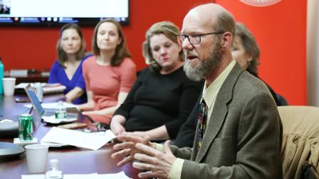 Professor Richard Johnson at a table addressing a group