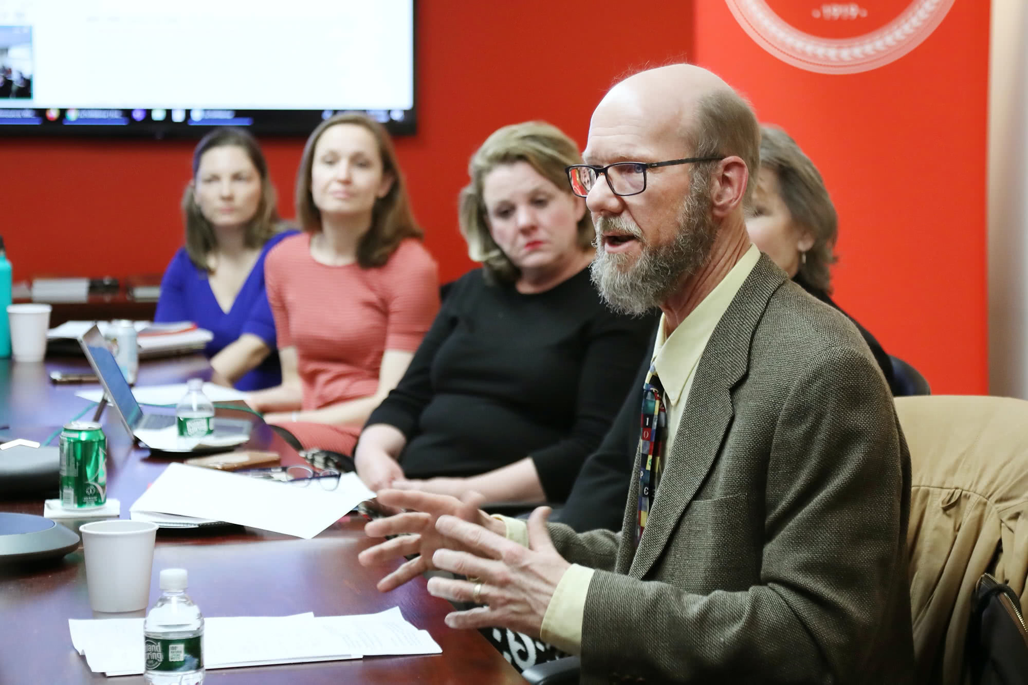 Richard Johnson at a table addressing a group of people