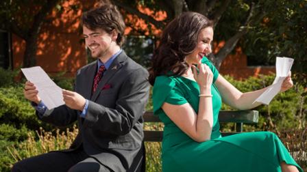 Sam Garrison (as Georg Nowack) and Bethany Brautigam (as Amalia Balash) sit on a bench with their love letters