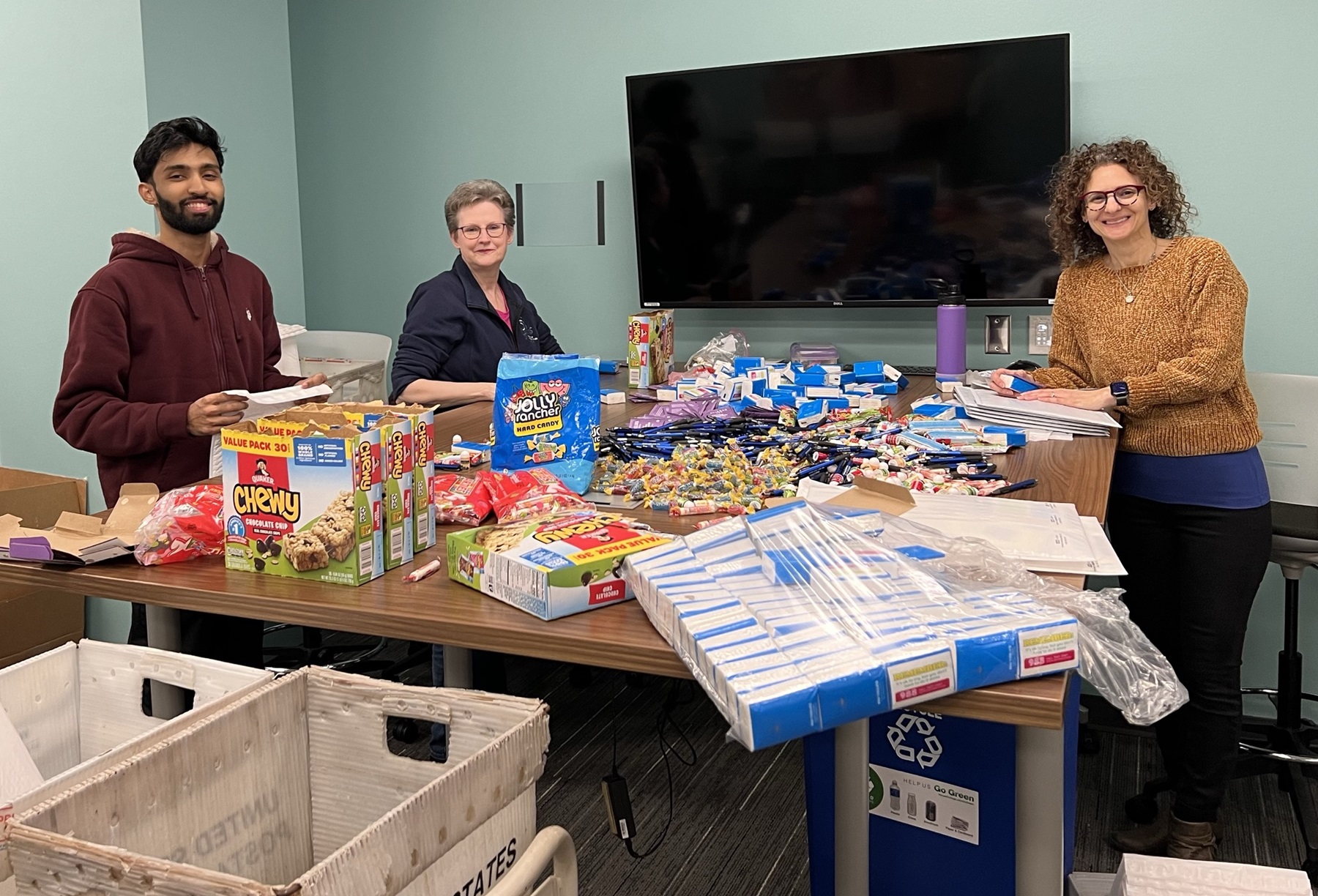 Atif Shareif, Stephanie Wootten and April Maman fill thrive kits with snacks.