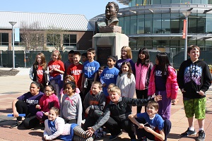 Ambassador School tour group takes picture in front of William Rainey Harper bust