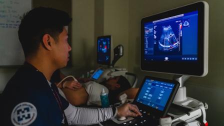 A Harper College student performs an ultrasound