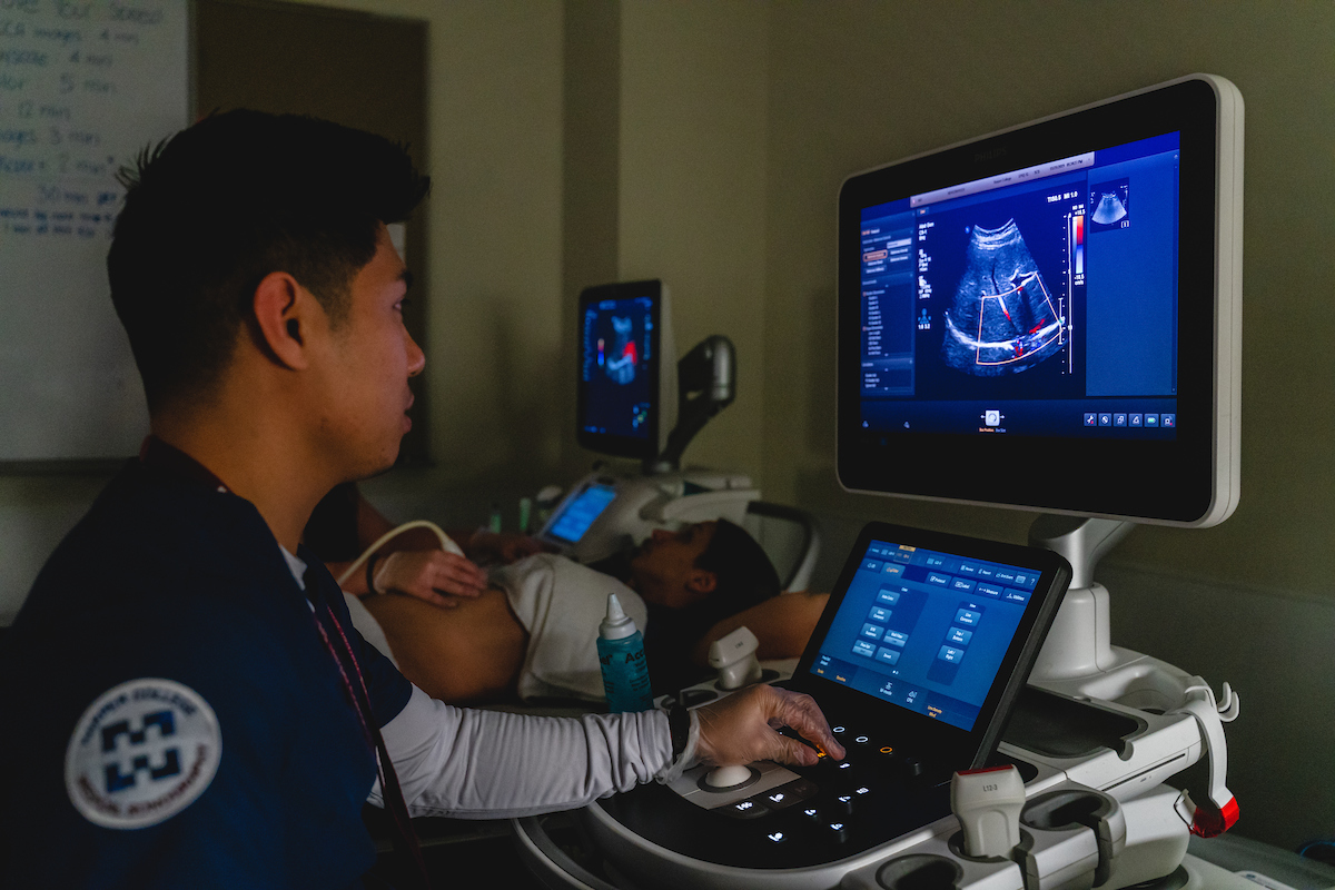 A Harper College student performs an ultrasound