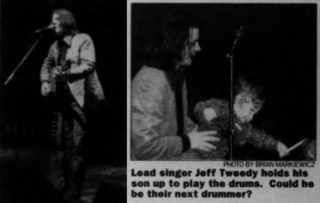 Two photos show Jeff Tweedy of Wilco performing at J Theatre in 1997. In one photo, he holds his son, Spencer, while he plays drums.